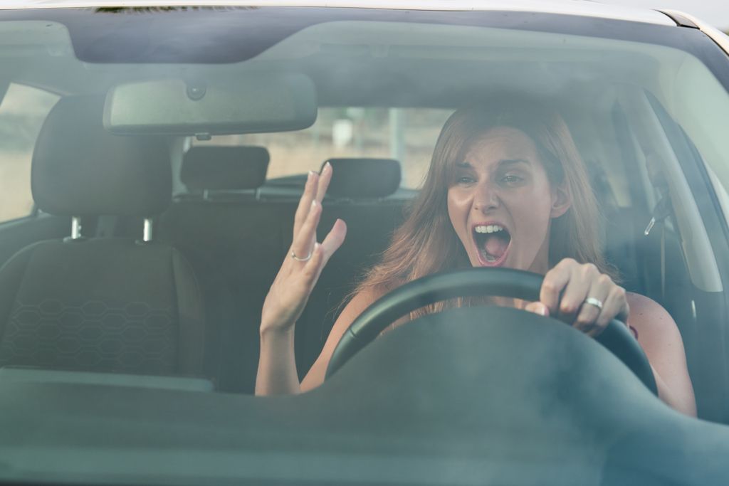 Woman in a car showing anger and frustration Woman in a car showing anger and frustration