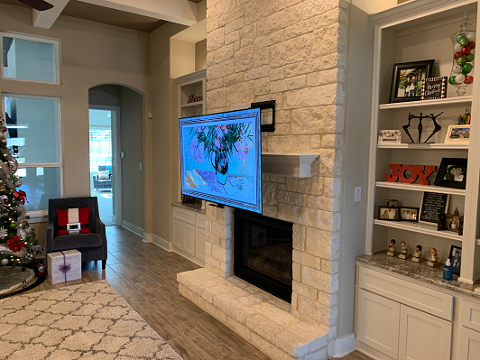 A living room with a fireplace and a flat screen tv mounted on the wall.