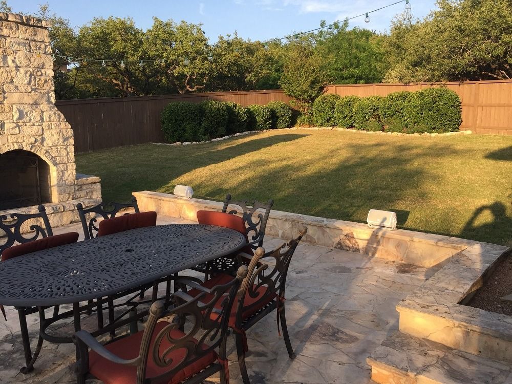 A patio with a table and chairs and a fireplace