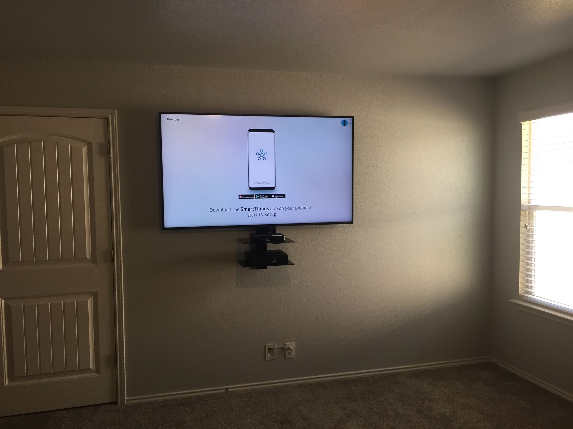 A large flat screen tv is mounted on a wall in a living room.