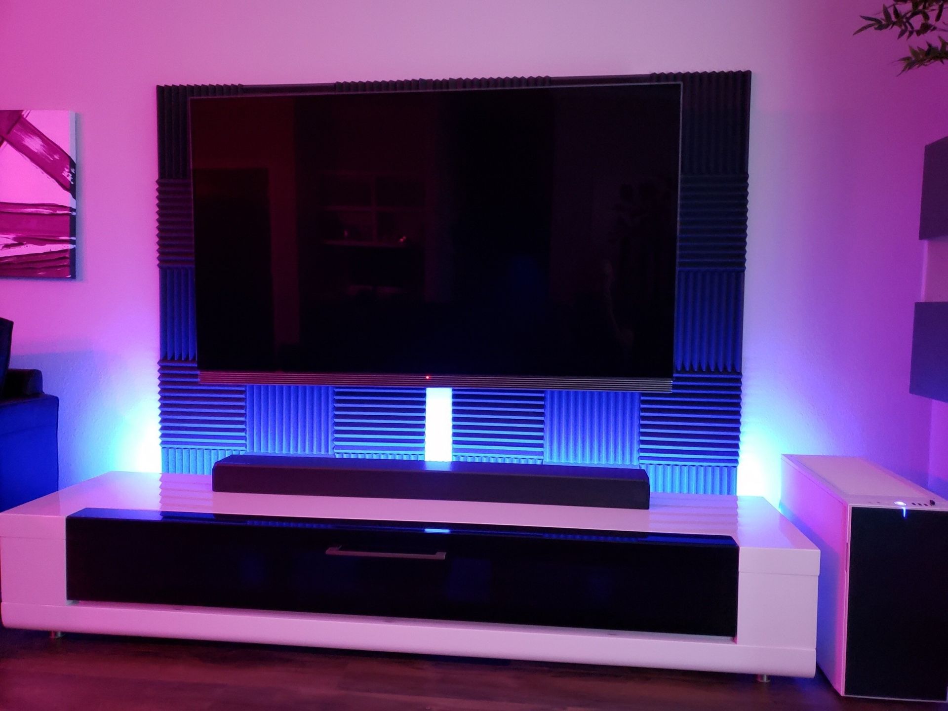 A flat screen tv is sitting on a stand in a living room.
