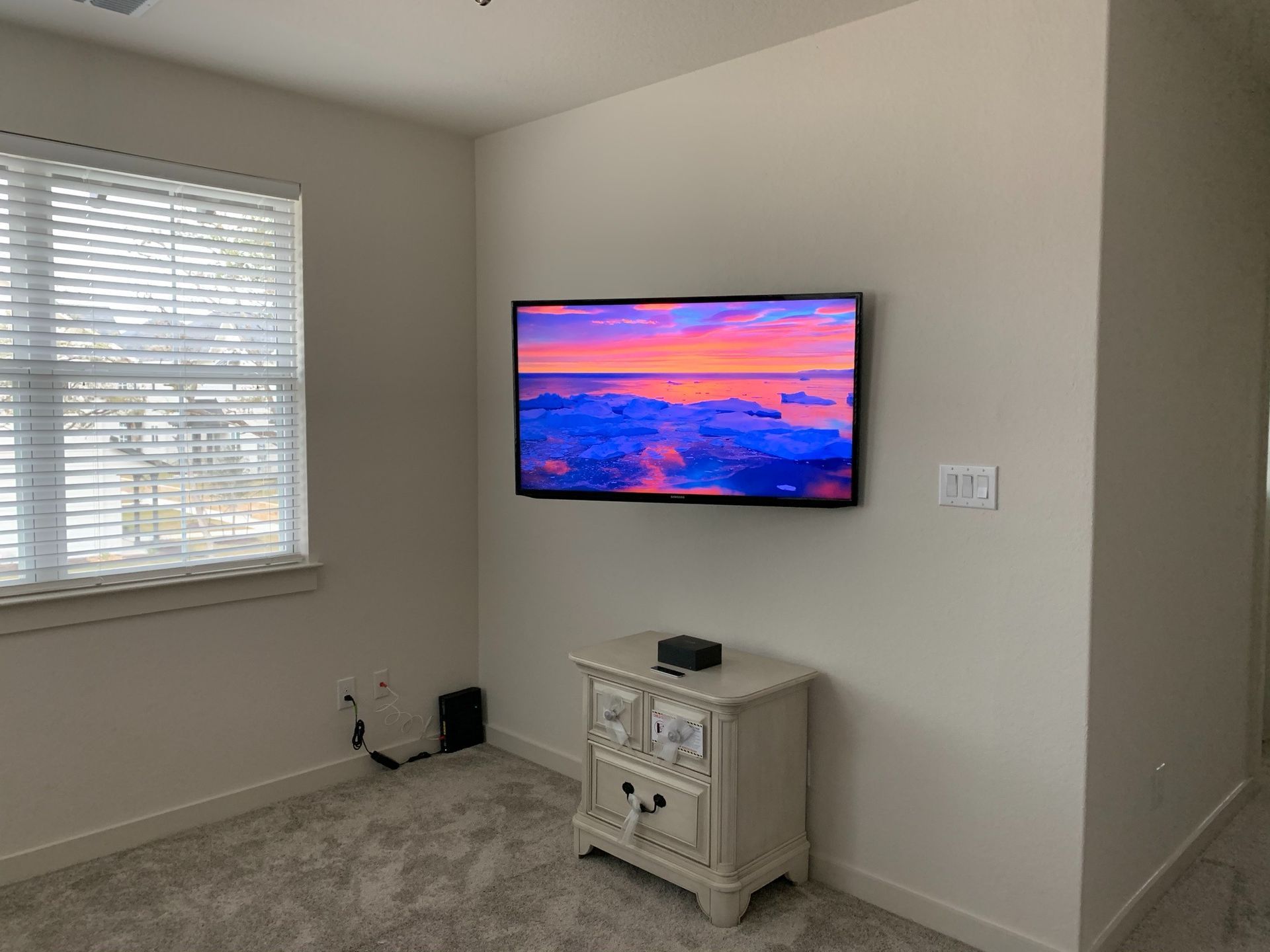 A bedroom with a flat screen tv mounted to the wall.