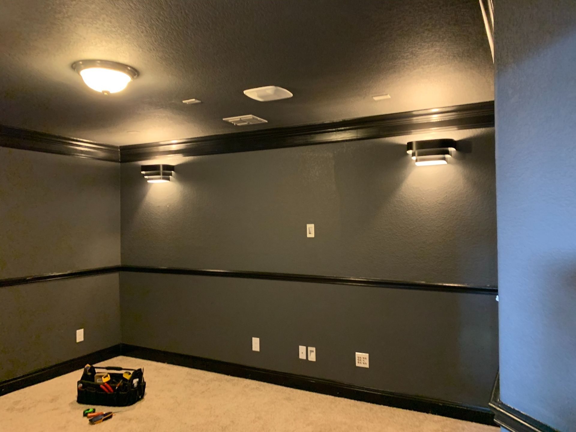 A room with a black ceiling and a bag on the floor.