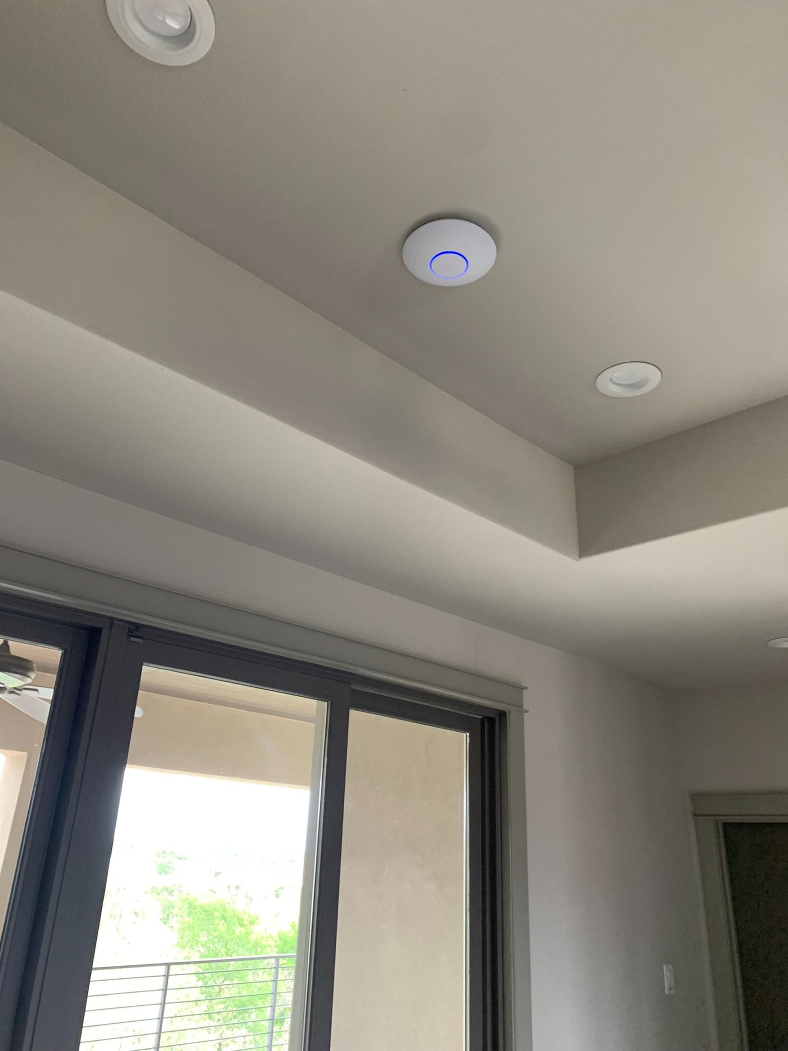 A room with a ceiling fan and a sliding glass door.