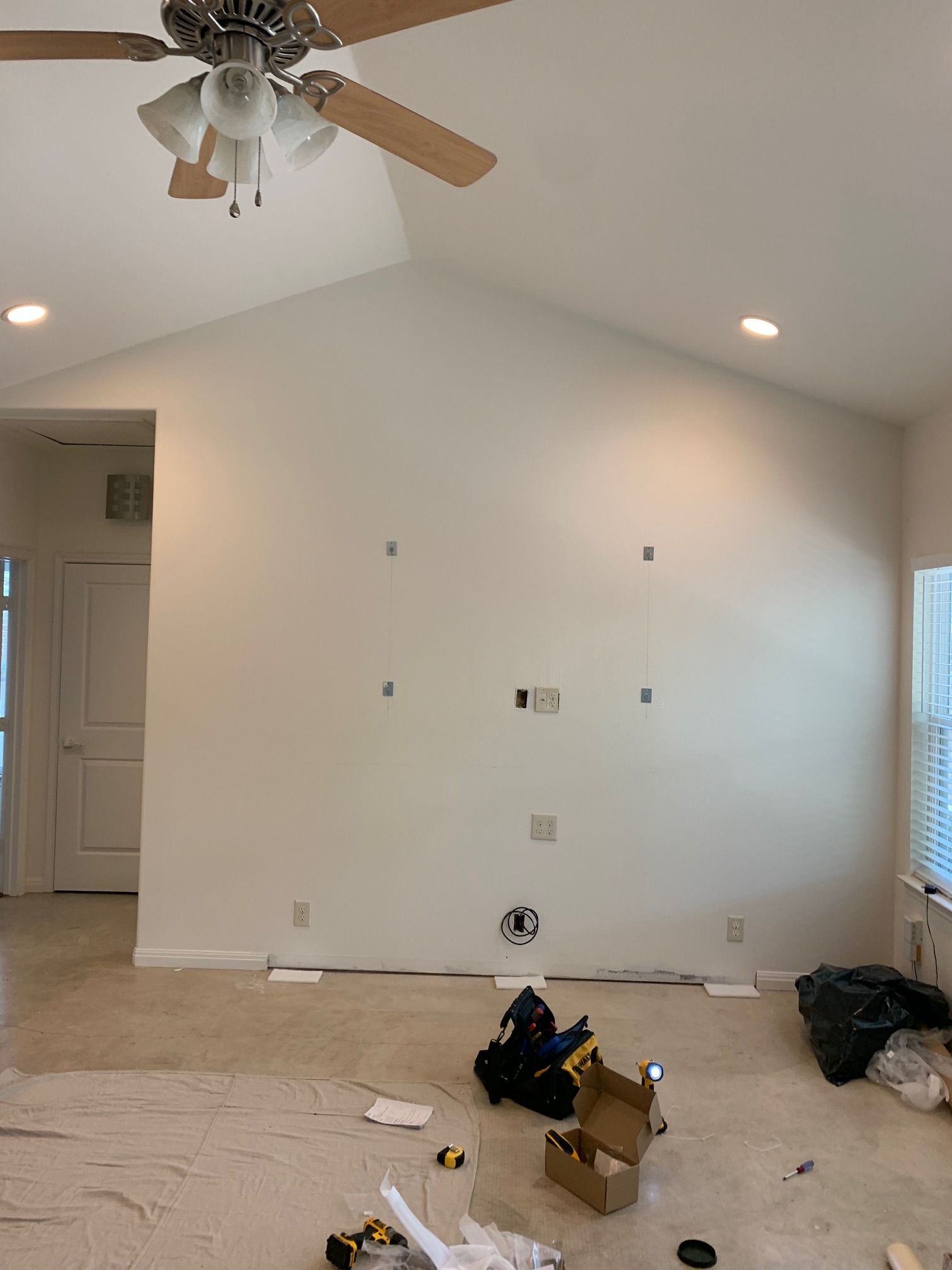 A living room with a vaulted ceiling and a ceiling fan.