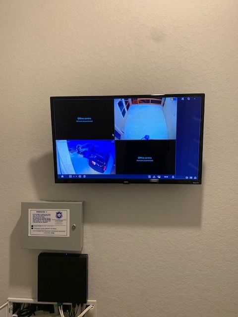 A flat screen tv is mounted on a wall next to a box