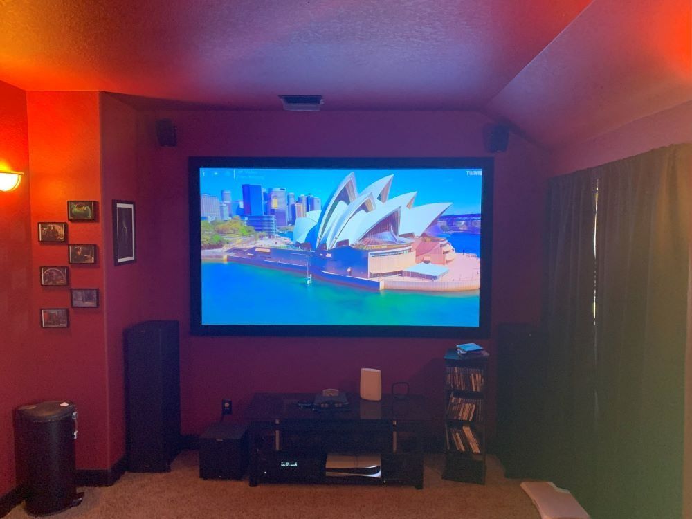 A projector screen is displaying a picture of the sydney opera house