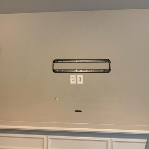 A tv mount is hanging on a wall in a living room.