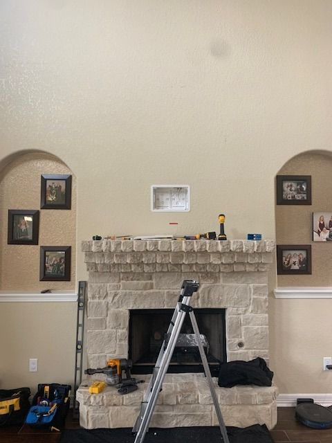 A ladder is sitting in front of a fireplace in a living room
