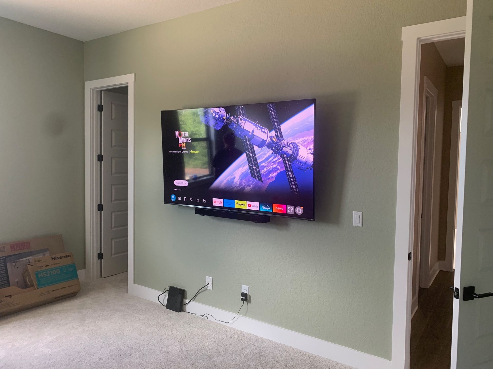 A large flat screen tv is mounted on a wall in a living room.