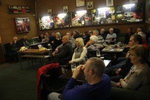 Audience seated in a dimly lit room watching a presentation or performance