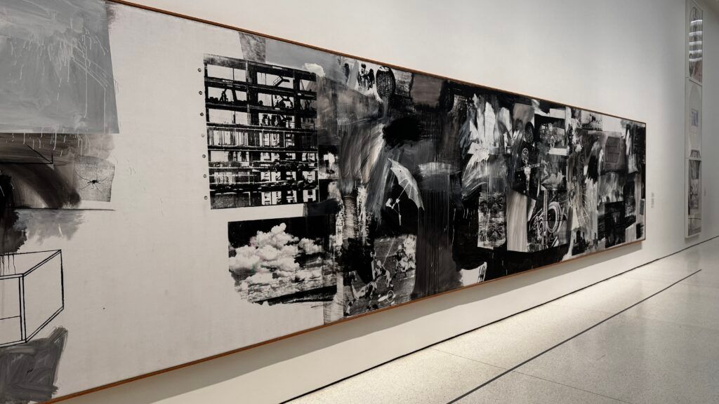 Long abstract black-and-white mural on a white gallery wall in a modern hallway