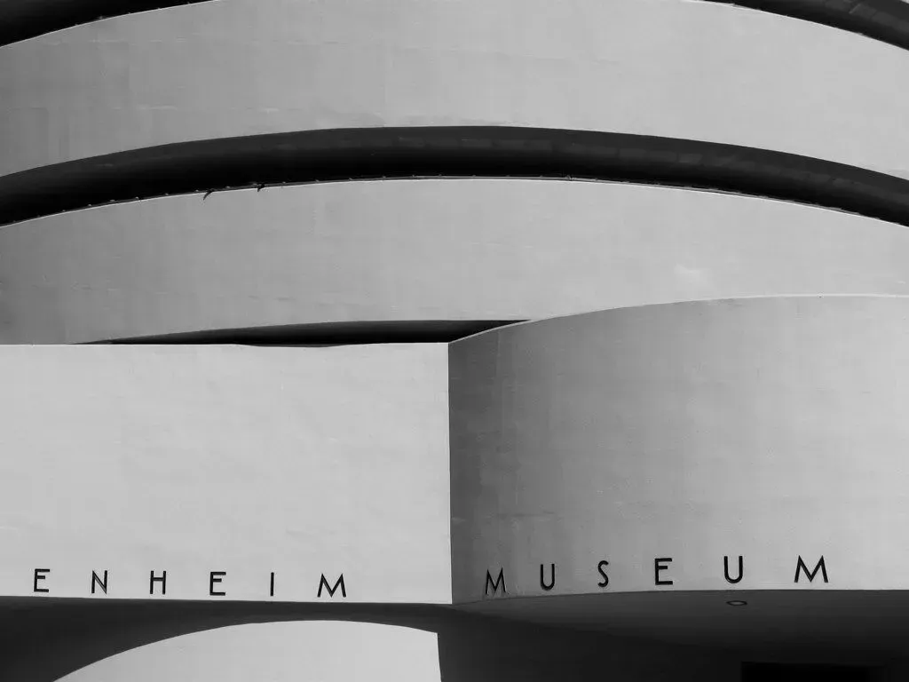 Entrance sign for the Enheim Museum with curved dark arches above a light wall.