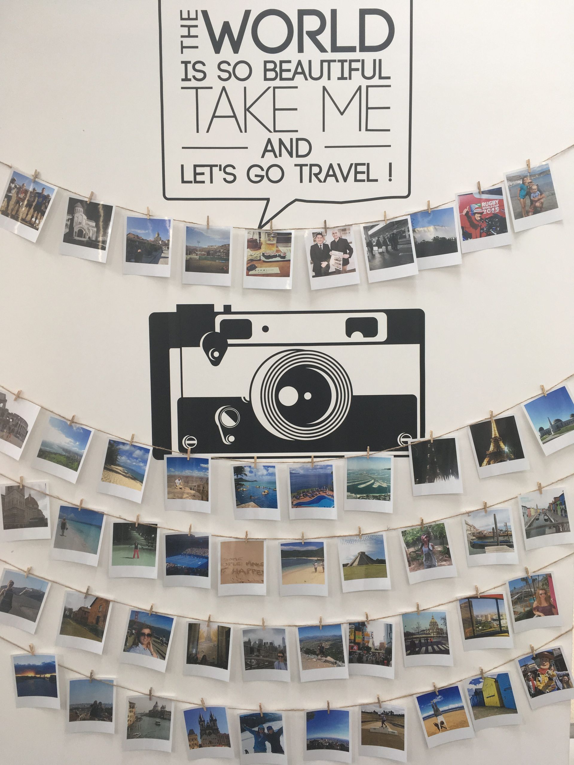 Wall display with travel photos, a camera graphic, and the quote “The world is so beautiful take me and let’s go travel!”
