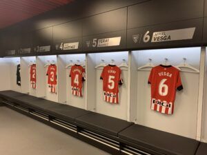 Soccer locker room with red jerseys numbered 4, 5, and 6 hanging in open lockers