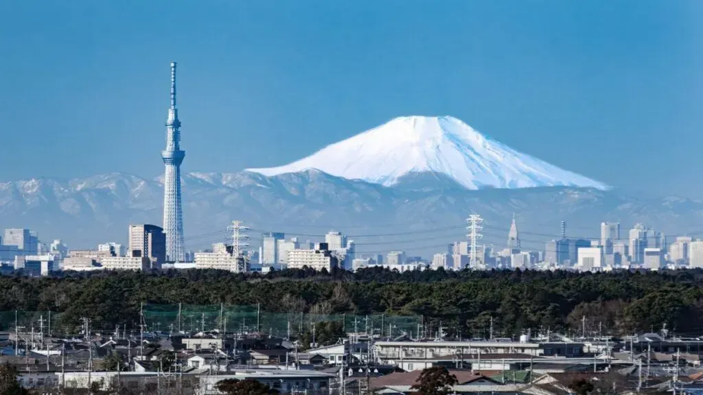 Tokyo skyline with Tokyo Skytree and snow-capped Mount Fuji under a clear blue sky