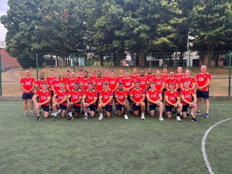 Soccer team in red jerseys posing for a group photo on a field