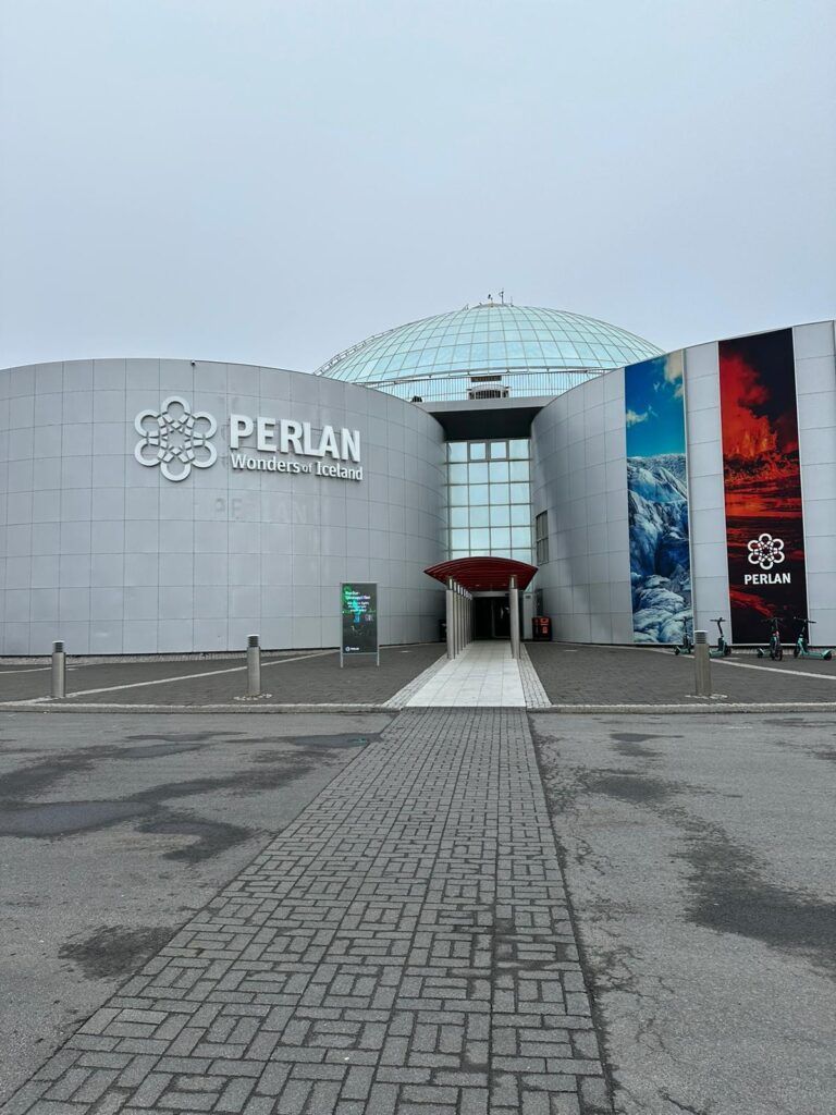 Perlan Museum entrance with gray facade, glass dome, and paved forecourt under an overcast sky