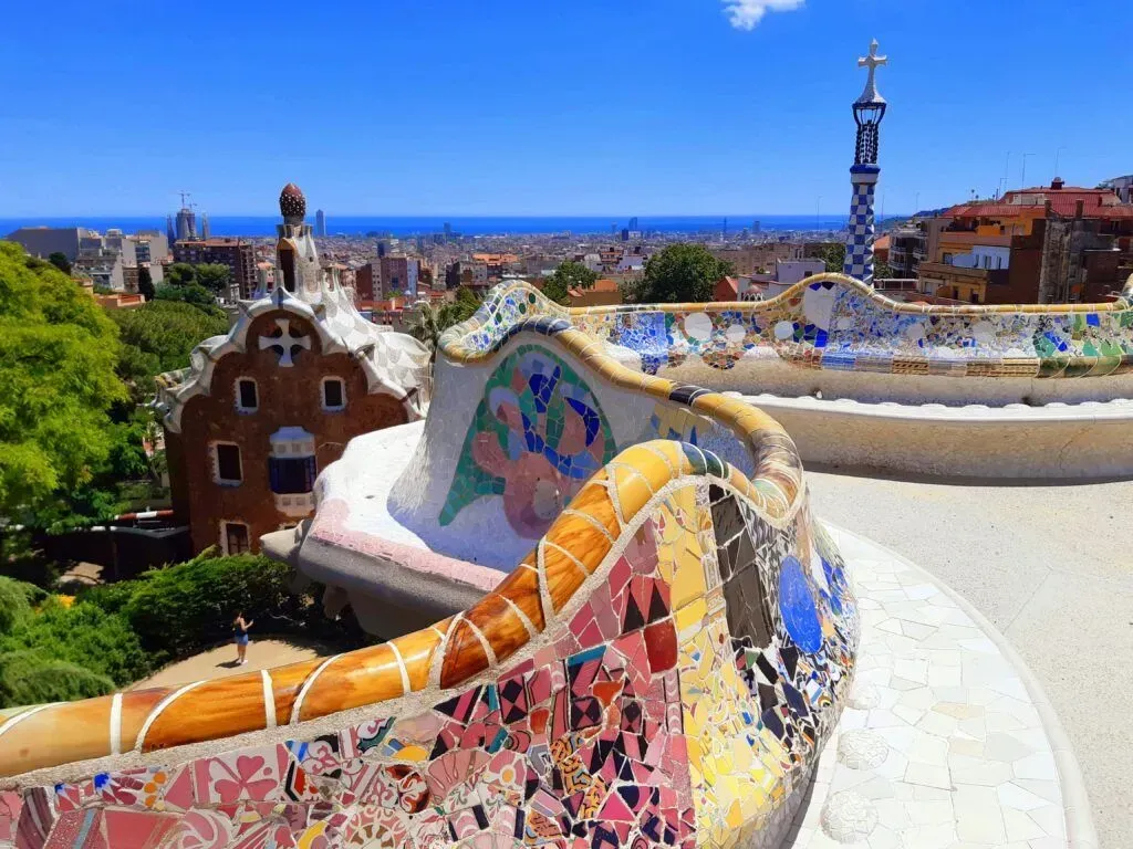 Colorful mosaic bench overlooking Barcelona skyline and sea under a bright blue sky