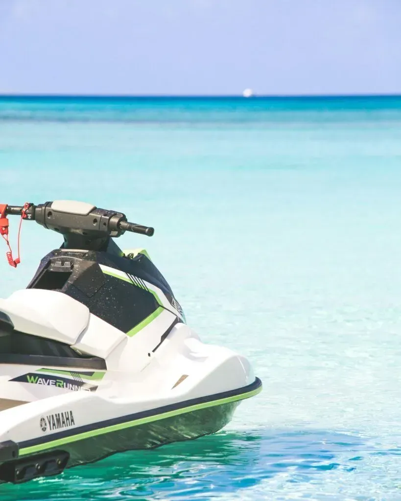 White jet ski on clear turquoise water near a bright tropical beach