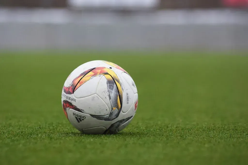 Soccer ball on a grassy field near the sideline