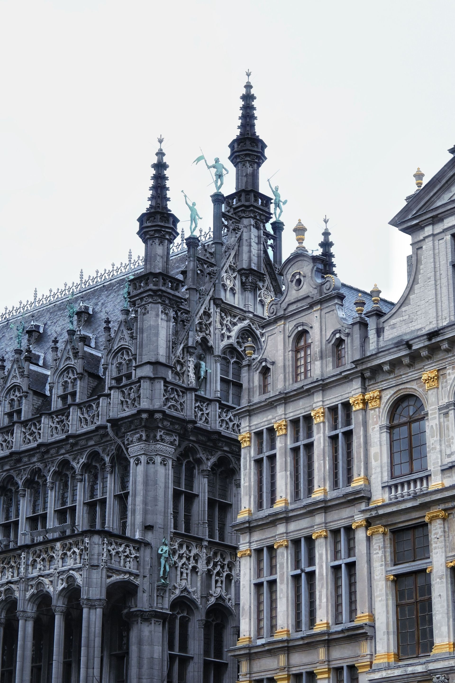 Ornate Gothic-style historic building facade with spires and lit windows at dusk