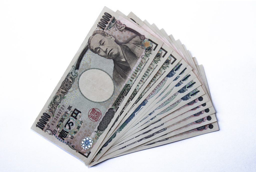Japanese yen banknotes fanned out on a white background