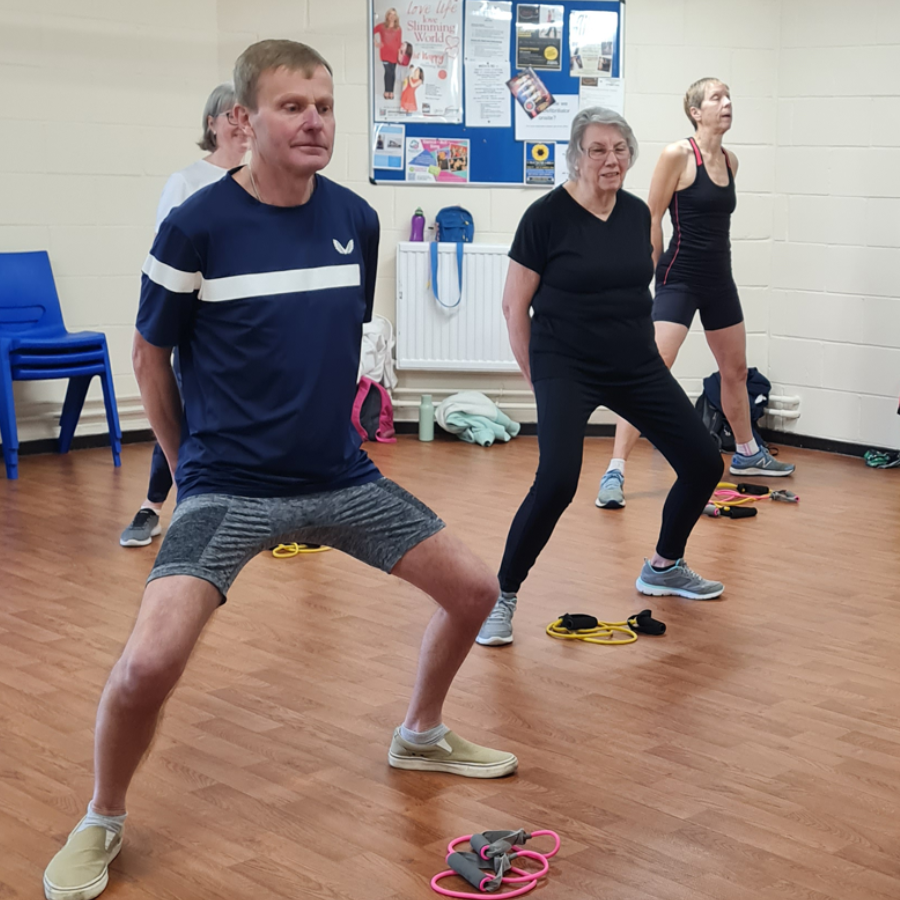A man and a woman are doing stretching exercises on a yoga mat.