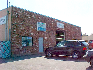 A black suv is parked in front of a brick building