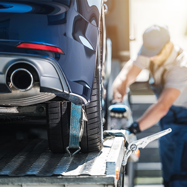 A car is being towed by a tow truck.