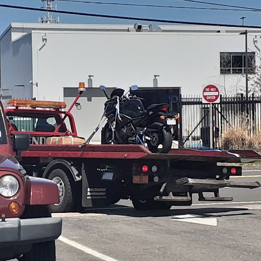 A tow truck with a motorcycle on the back of it