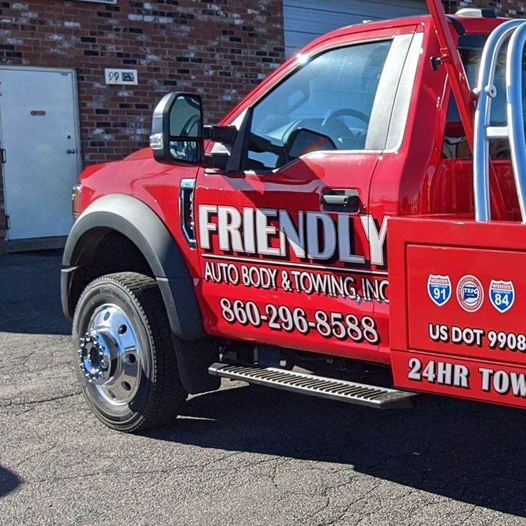 A red tow truck from friendly auto body & towing inc