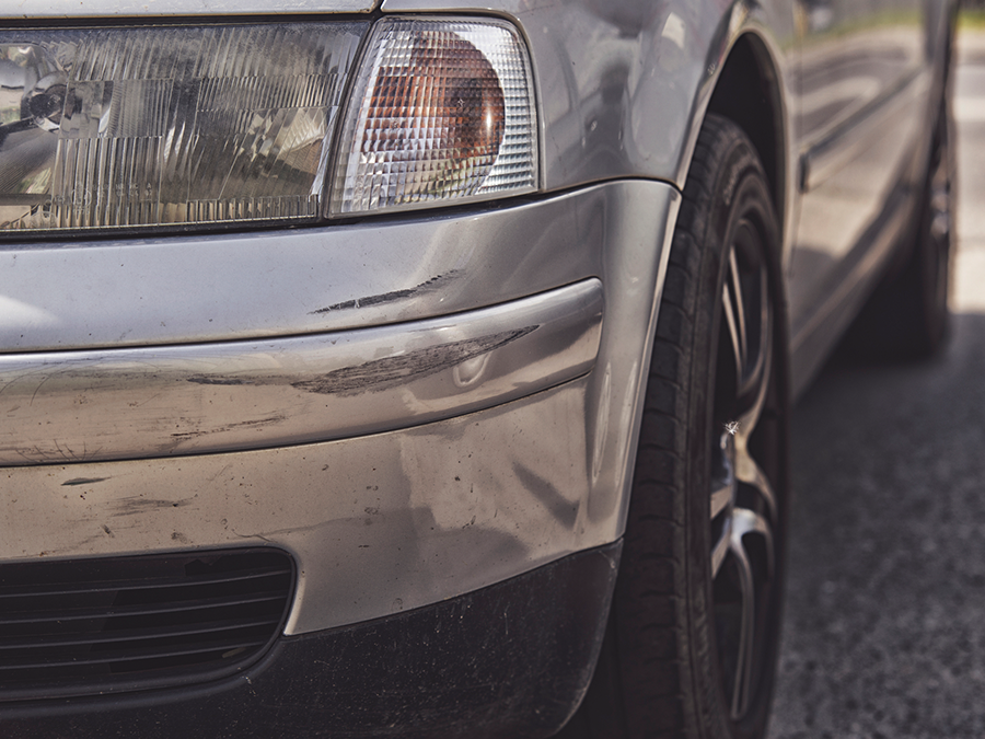 A silver car is parked on the side of the road.