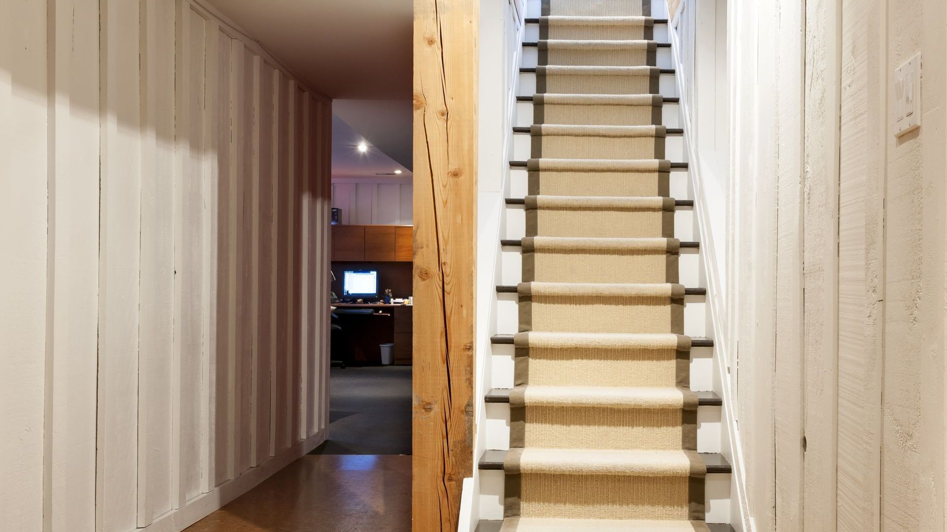 A hallway with stairs leading up to the second floor of a house.