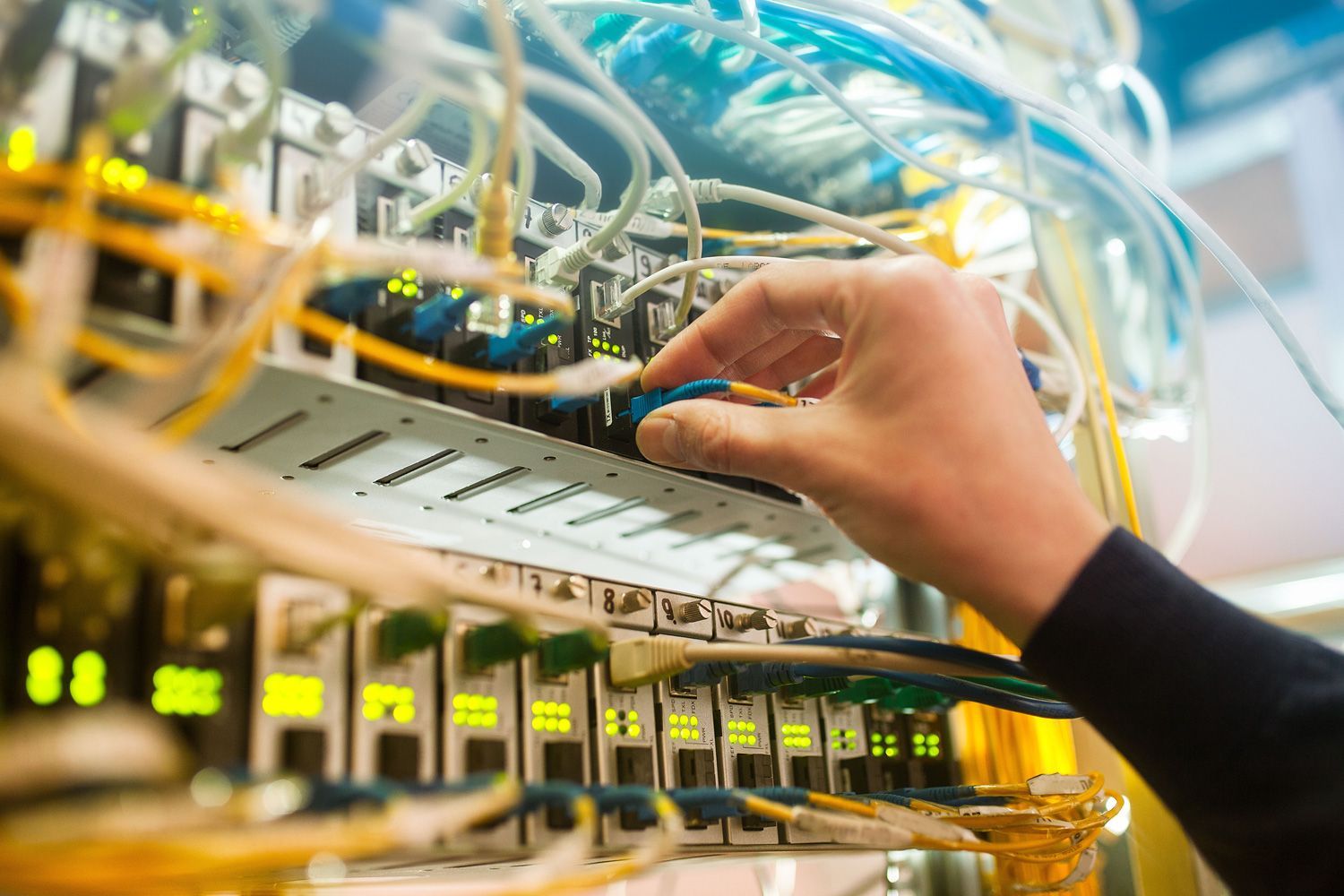 engineer in a data processing center of ISP Internet Service Provider hold fiber patch cords