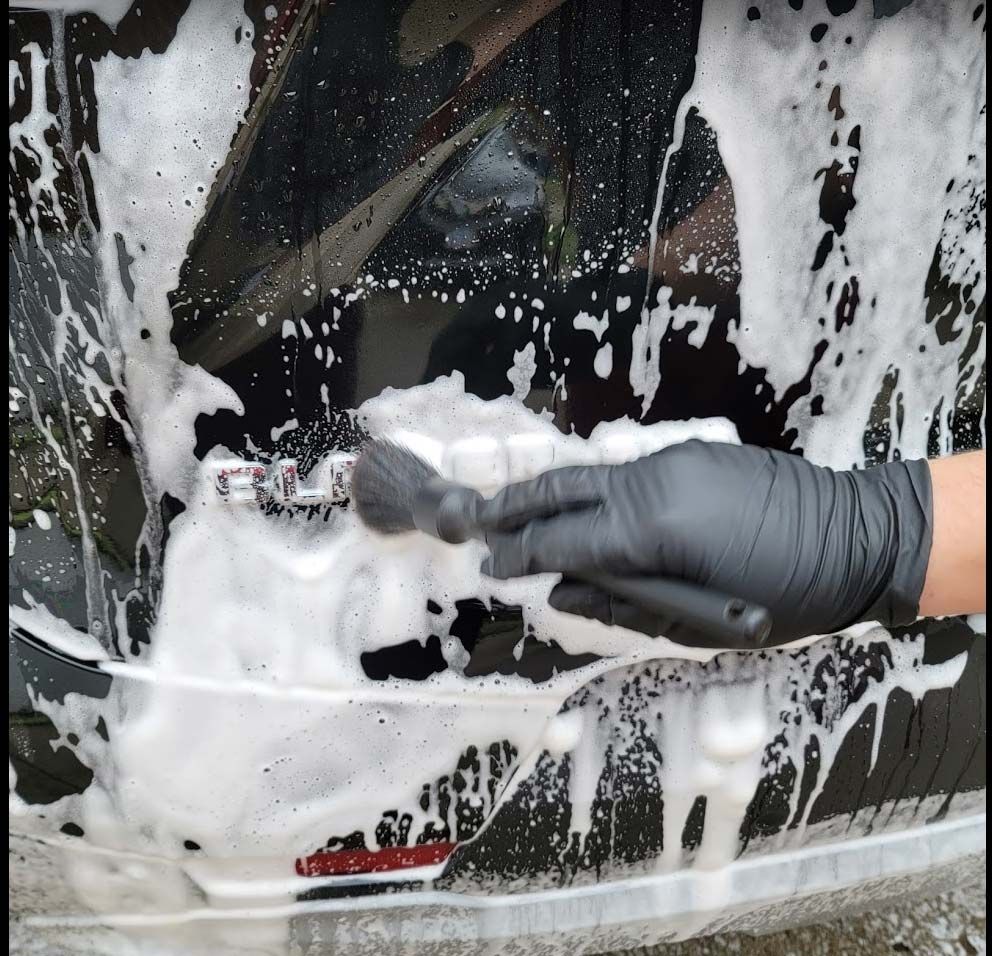 a man detailing a vehicle's hood