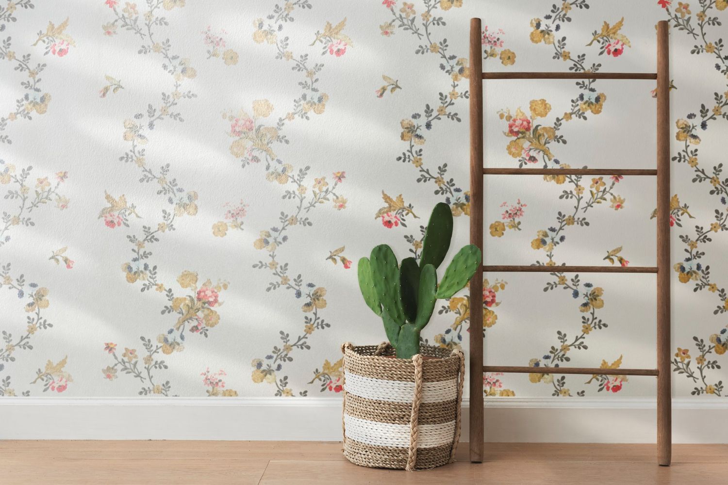 Papel pintado floral detrás de una estantería de madera con forma de escalera y un cactus en maceta sobre un suelo claro.
