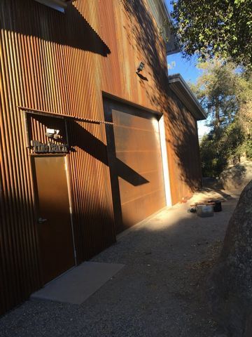 A rusty garage door with a mailbox on the side of it