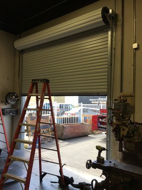 A ladder is sitting next to a garage door.