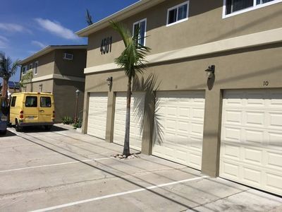 A yellow van is parked in front of a building with garage doors