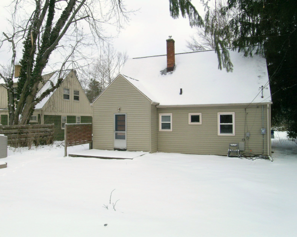 A house with a chimney is covered in snow