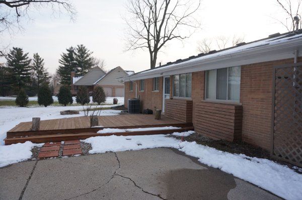 A brick house with a wooden deck in front of it