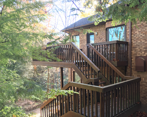 A brick house with a wooden deck and stairs