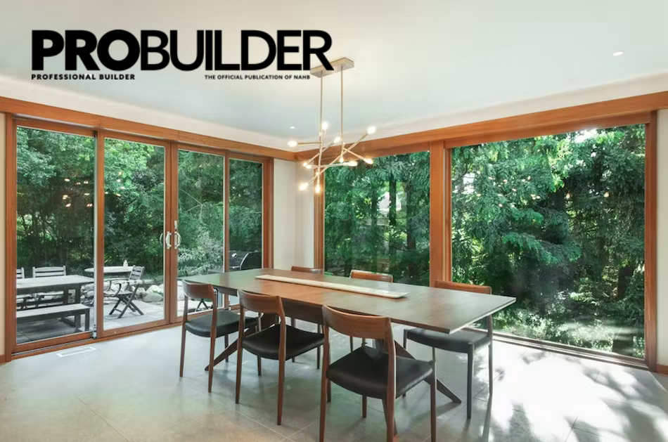 A dining room with a table and chairs and a probuilder logo on the wall.