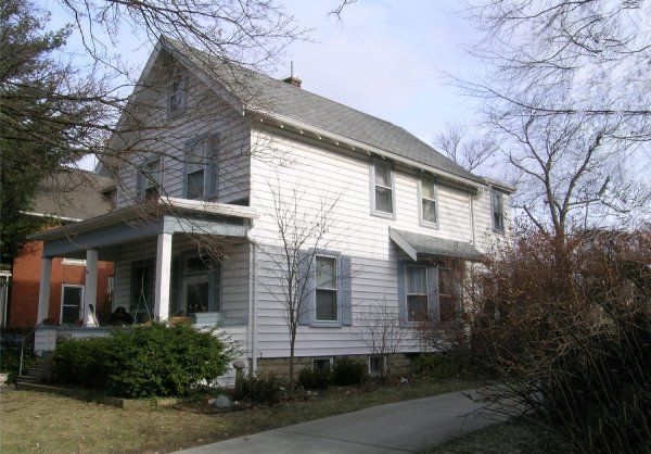 A white house with a gray roof and a porch