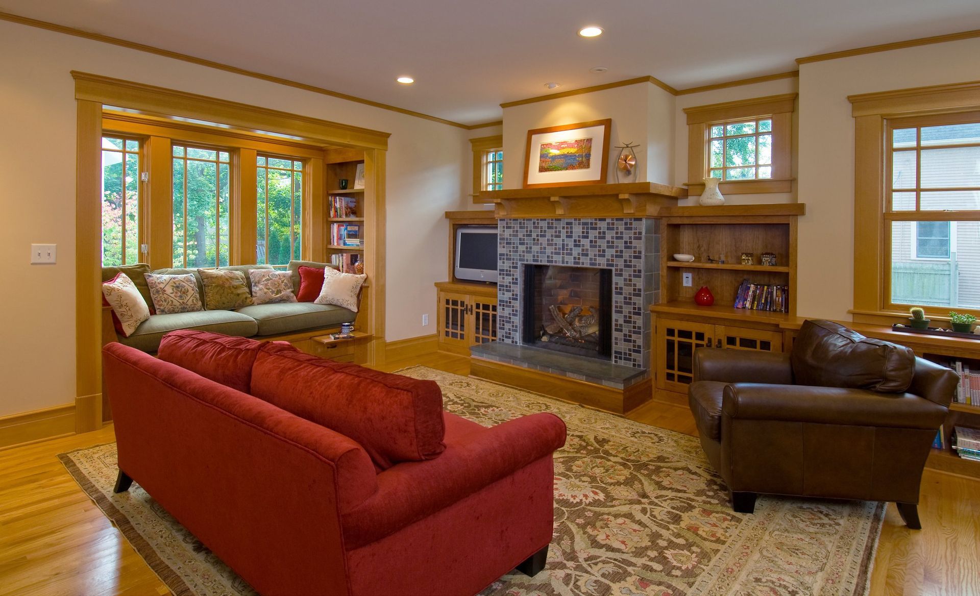 A living room with a red couch and a fireplace.