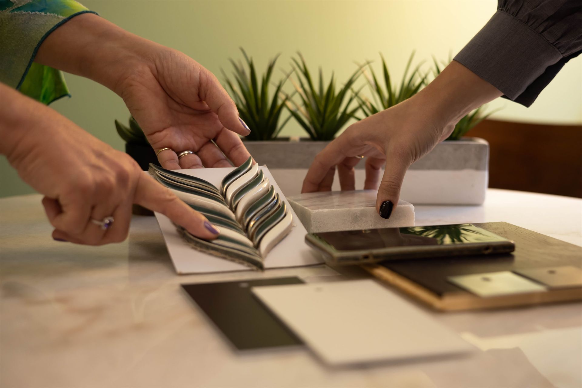 Two people are looking at a piece of fabric on a table.