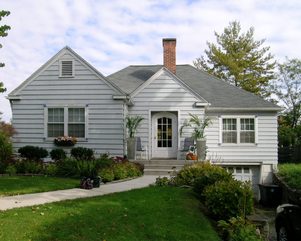 A small white house with a brick chimney