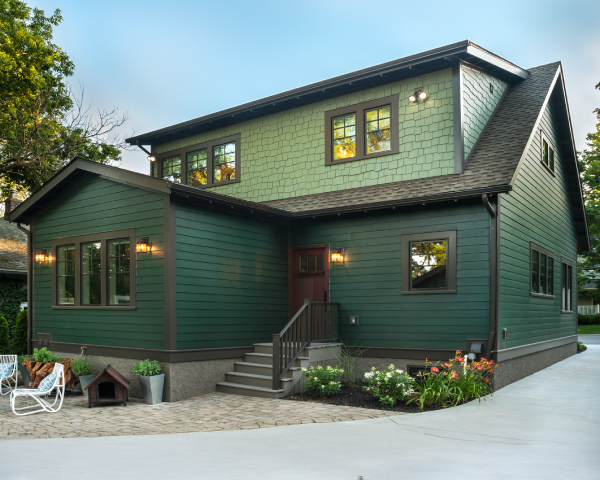 A green house with a dog house in front of it