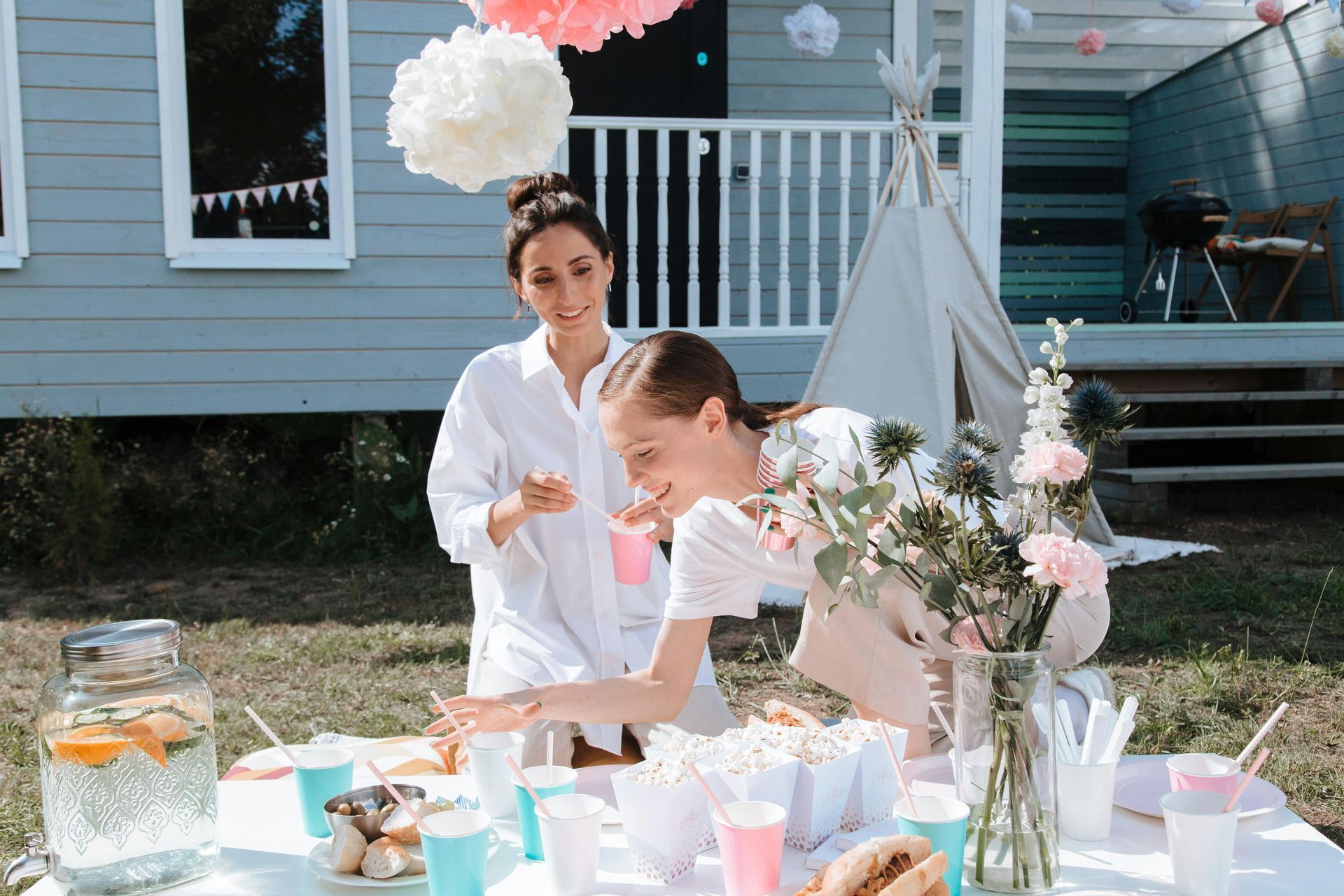 Two women are standing next to each other at a table.